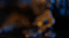 Close-up pan from a patterned fabric belt to its ornate, traditional filigree metal buckle. Dramatic blue and warm lighting highlights the intricate details and craftsmanship. - Powered by Shutterstock - Get 15% off with code: PIKWIZARD15