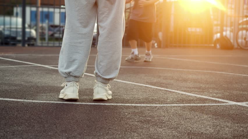 Quick-witted teen easily outmaneuvers his older bro by dribbling ball while playing basketball in park at sunset in cityscape. ball interception - Powered by Shutterstock - Get 15% off with code: PIKWIZARD15