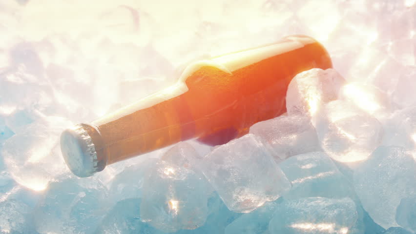Beer Bottle On Ice Cubes In Sun Glow