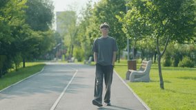Young guy walking in a city park with hands in his pockets, captured full body. Calm expression, sunshine, and trees highlight relaxed teenage energy. - Powered by Shutterstock - Get 15% off with code: PIKWIZARD15