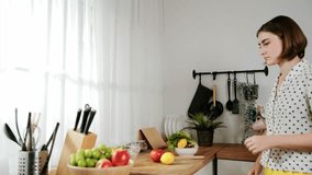 Attractive caucasian mom chopping fresh vegetable for making salad. Happy energetic smart mother working in modern kitchen while cooking healthy food for breakfast. Food preparation concept. Pedagogy. - Powered by Shutterstock - Get 15% off with code: PIKWIZARD15