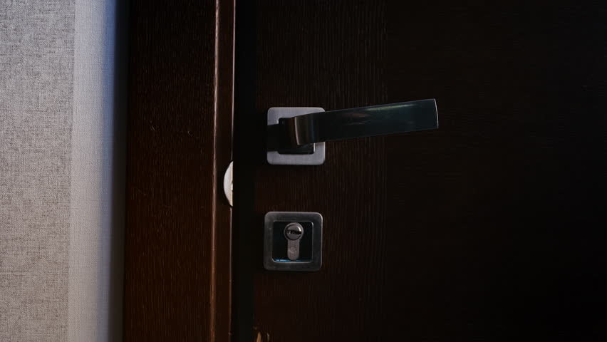 Hotel resident hanging do not disturb sign and closing door, privacy request