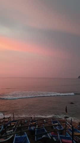 Serene coastal sunset with boats resting along the shore capturing warm skies, tranquil water, and the poetic rhythm of evening by the sea
