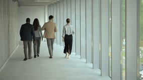 Professional business team walking confidently through sunlit modern office hallway, representing corporate collaboration and workplace success - Powered by Shutterstock - Get 15% off with code: PIKWIZARD15