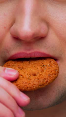 Portrait of Adult Man Eating Sweet Food on Camera. Crop Face of Alone Real Person on Diet Consuming American Cookie as Lunch Snack. Confident Male Human Posing with Tasty Sugary Fastfood as Quick Meal
