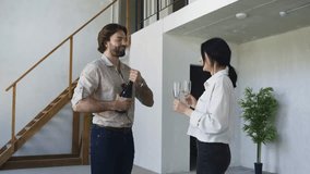 A joyful couple opens a bottle of champagne in their newly purchased two-level apartment, celebrating the excitement of finally owning their dream home - Powered by Shutterstock - Get 15% off with code: PIKWIZARD15