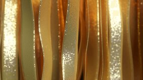 Luxurious golden ribbons with perforated surface and glittering texture flowing smoothly, creating elegant abstract composition with graceful curving motion. 3D Illustration - Powered by Shutterstock - Get 15% off with code: PIKWIZARD15