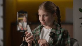 Shocked amazed Caucasian little girl recording video blog playing game at home child kid influencer blogger filming review shock holding mobile phone play smartphone app online streaming video tripod - Powered by Shutterstock - Get 15% off with code: PIKWIZARD15