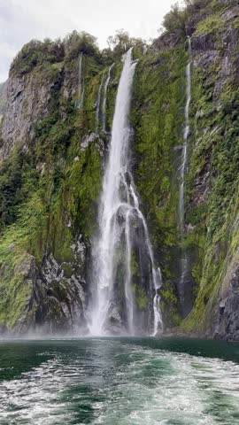  Picturesque view of the waterfall from the water. Cruise on a boat in Milford Sound, New Zealand.