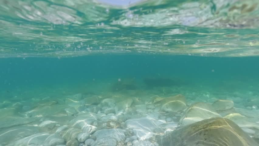 Calm sea water near shore at Butterfly Valley, Oludeniz, boat in distance. Split half underwater video