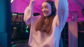 Excited woman gamer girl female streamer in headphones celebrating victory at computer online game playing joyful reaction smiling in neon light at home room at night addiction gaming success winning - Powered by Shutterstock - Get 15% off with code: PIKWIZARD15