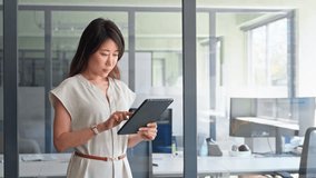 Smiling ceo entrepreneur businesswoman leader using touchscreen pc device in office. Asian middle-aged woman using tablet reading news browsing, doing online work, business communication. Copy space - Powered by Shutterstock - Get 15% off with code: PIKWIZARD15