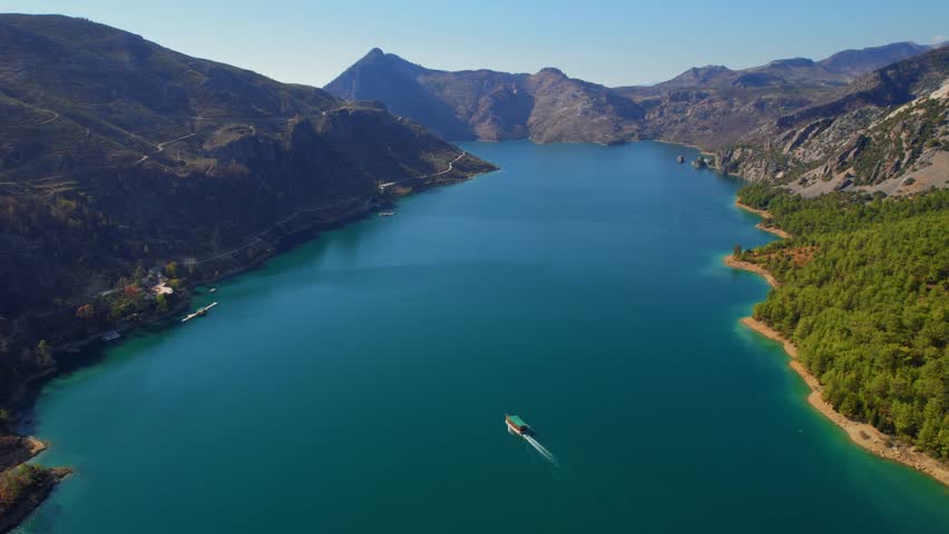 Green Canyon Antalya with tourist ship move on mountain lake, Turkey Aerial top view.