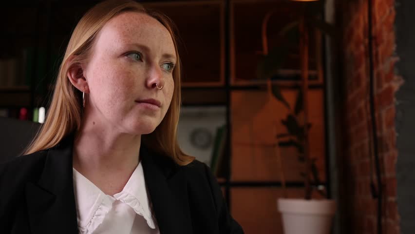 Stylish redhead woman, formally dressed, expertly types on her laptop in modern office. Concept of efficiency and modern management, blending technology with vibrant office lifestyle.