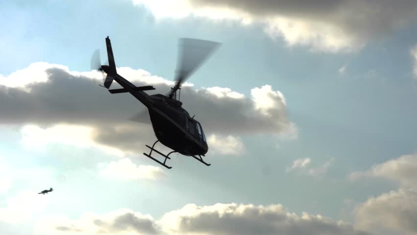 A helicopter flies silhouetted against the evening sky in Israel, showcasing dramatic clouds and serene moments.