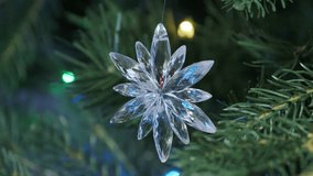 Elegant Crystal Snowflake Ornament Hanging on Lush Green Christmas Tree with Festive Lights - Powered by Shutterstock - Get 15% off with code: PIKWIZARD15