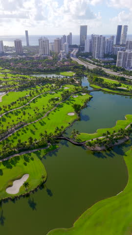 Vertical stock video Aventura Miami Florida. 4k aerial view of golf courses and highrise towers