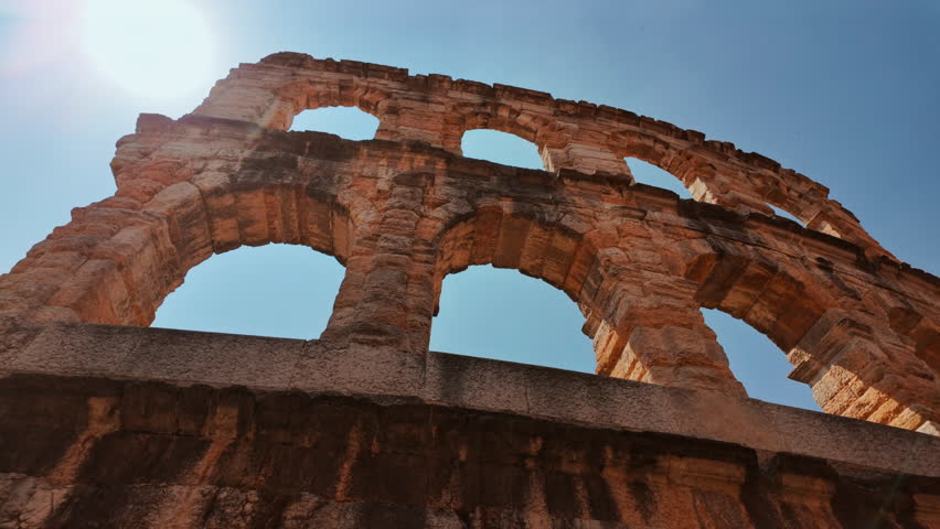 Exterior view of the oval Arena di Verona, Roman arena framed by shadowed corridors and textured stonework, Verona, Veneto, Italy
