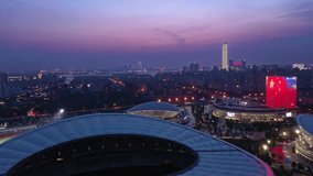 Experience a breathtaking aerial view of Suzhou Olympic Sports Center at night. The stadiums glow brightly against the twilight sky, showcasing the dynamic urban landscape of Suzhou. - Powered by Shutterstock - Get 15% off with code: PIKWIZARD15