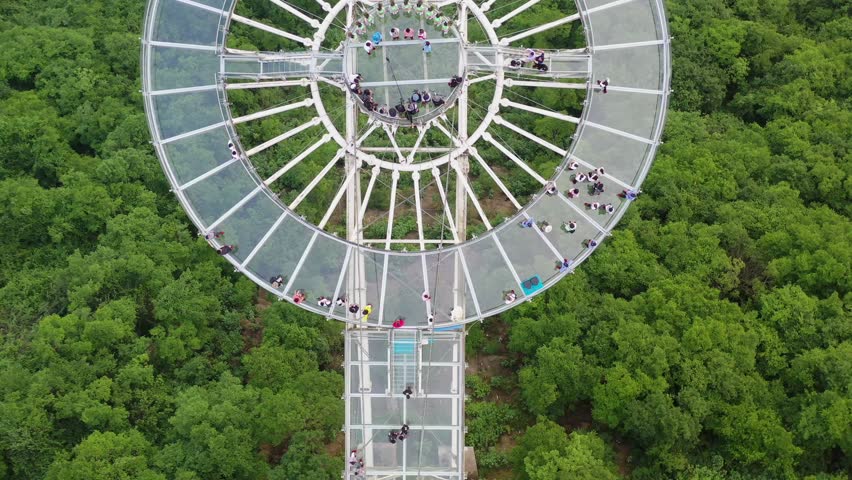 Experience breathtaking views of Hubei Huangshi Sky City as people gather on its unique observation platform surrounded by lush greenery. Marvel at the architectural beauty and nature.