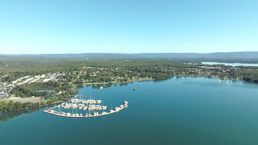 Aerial drone shot flying past a small marina in Lake Macquarie