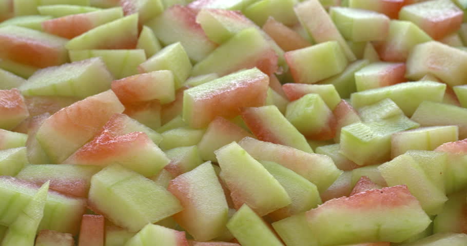 Peeled watermelon rind chunks background texture. Watermelon rind is edible after heat treatment (stir-fry, braise, or cook). Zero waste food concept. Selective focus, table spin.