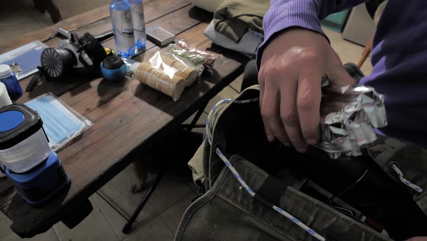Military Survival Kits. A man collects a backpack with basic necessities in case of war or nuclear threat