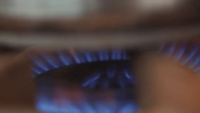 A close up of a gas burner with blue flames. Concept of warmth and comfort, as the blue flames dance and flicker in the background - Powered by Shutterstock - Get 15% off with code: PIKWIZARD15