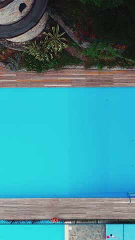 Aerial view of a swimming pool and a medieval tower in camogli, italy, rotating clockwise