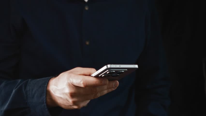 Close-up of male hand holding modern smartphone for online banking and crypto payments. Showcases mobile financial apps and digital transaction convenience.