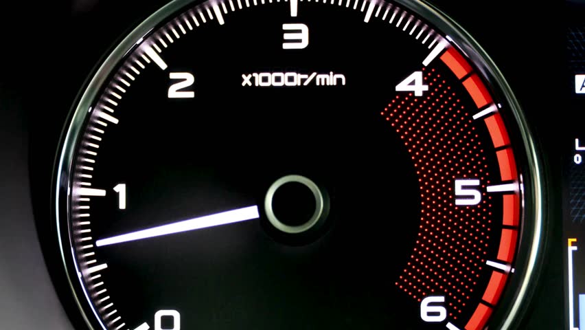 This image shows a car's tachometer, indicating the engine's revolutions per minute (RPM). The needle is around 1000-1500 RPM, and there's a redline warning area on the right. A play button overlay.