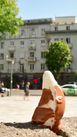 Vertical time lapse Ice cream melts rapidly under intense sun heat during summer morning in city. Symbolic visual metaphor global warming, rising temperatures, urban heat islands, public health danger