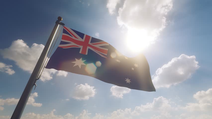 Australia Flag waving on a Flagpole with a cloudy blue sky background