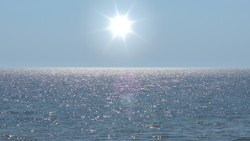 A serene video of a glistening ocean surface under the bright summer sun. This calm and beautiful background is perfect for meditation, spa, or travel concepts