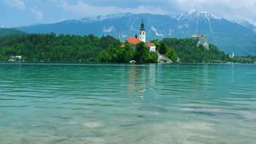 Church of the Assumption of Mary in the center of the lake Bled. Small island on Bled Lake in Slovenia, warm summer day sun - Powered by Shutterstock - Get 15% off with code: PIKWIZARD15
