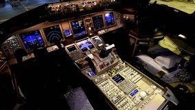 View of cockpit in modern aircraft featuring intricate control systems, illuminated displays, and navigation instruments during night hours. Shadows play across various panels. - Powered by Shutterstock - Get 15% off with code: PIKWIZARD15