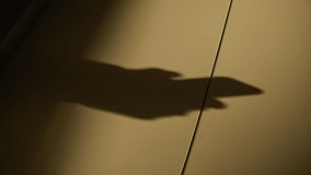 Shadow of male hands holding mobile phone typing and sending text messages. Businessman person sending sms or using and working with smartphone. Silhouette on wall during sunset or sunrise light - Powered by Shutterstock - Get 15% off with code: PIKWIZARD15