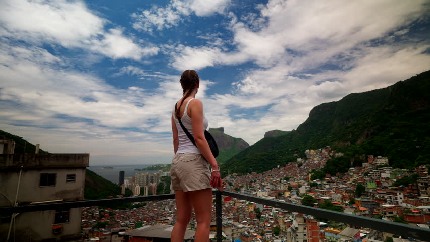 Female tourist atop building lookout point over Rochina favela in Rio de Janeiro