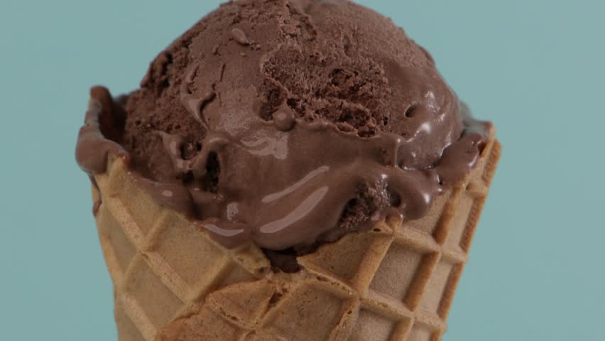 melting chocolate ice cream in waffle cone blue background