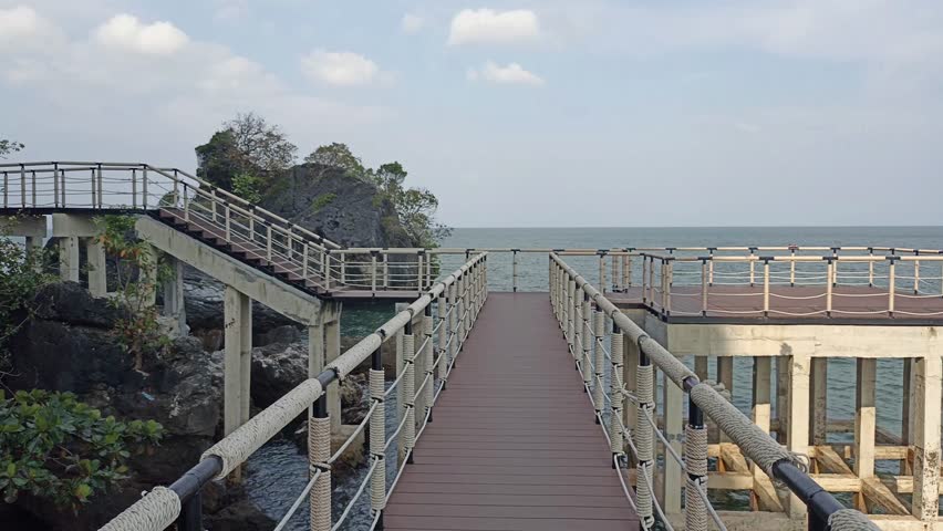 elevated pedestrian walkway beside calm sea ocean. Peaceful tranquil nature seascape scene for relaxing