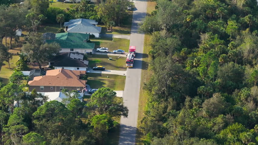 Lights from fire engine and ambulance during home medical emergency. Drone point of view.