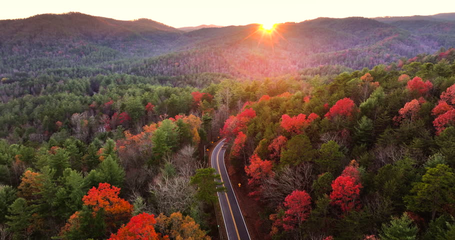 Peaceful mountain road in North Carolina during peak fall season at sunset. Appalachian landscape filled with vivid autumn colors