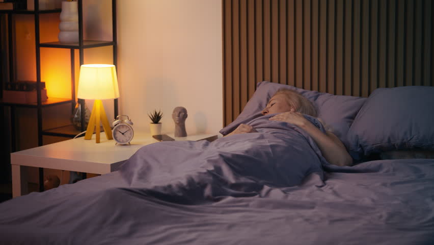 Middle-aged woman sleeping peacefully in bed at night, enjoying healthy rest
