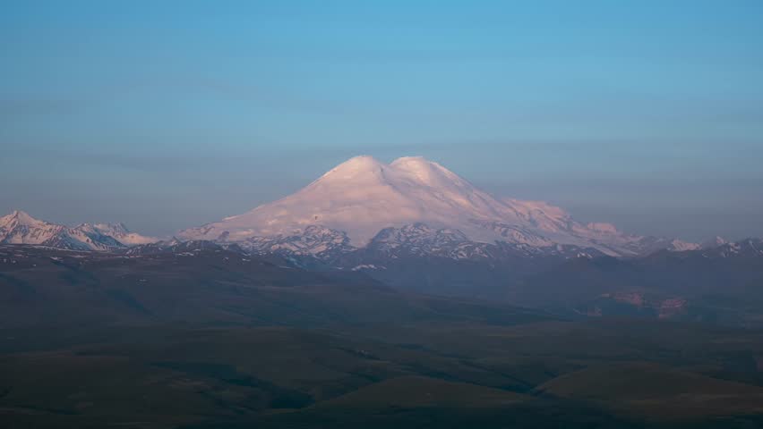 Timelapse of sunrise on the top of Elbrus. Wind drives snow on the top of Elbrus