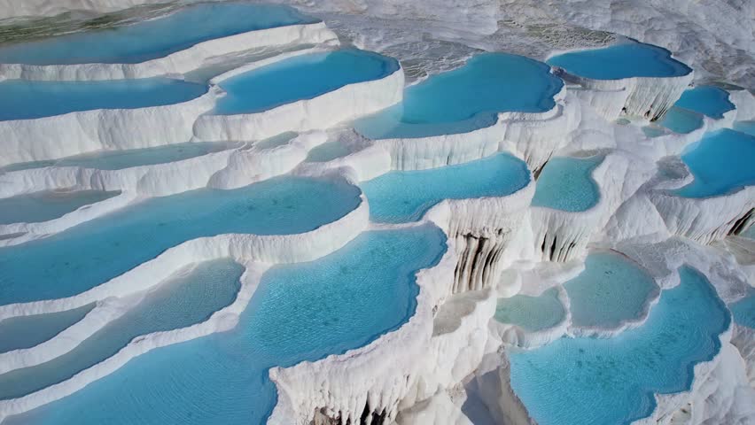 Pamukkale Turkish, Natural travertine pools terraces with blue water, aerial top view.