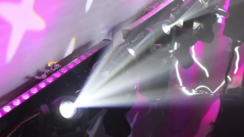 Bright spotlights and smoke, creating an atmospheric backdrop for a concert or performance