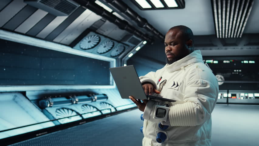Astronaut in spacecraft using laptop to run telemetry data analysis. Man in spaceship wearing spacesuit analyzing mission logs on notebook during planetary exploration, camera A