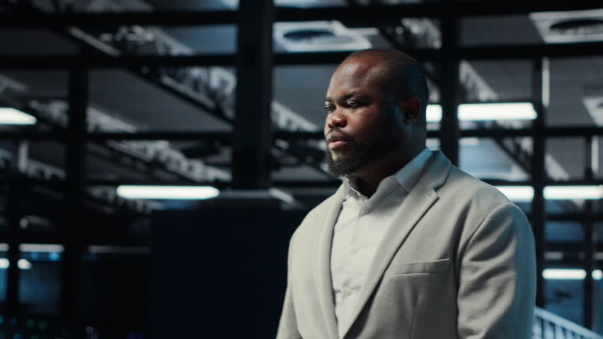 Admin working in high tech server hub capable of processing and storing vast amounts of data. African american IT specialist troubleshooting server rows controlling network resources, camera B - Powered by Shutterstock - Get 15% off with code: PIKWIZARD15