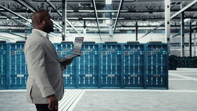 Smiling data center programmer using laptop to upgrade system stability. Jolly african american server hub IT expert coding, optimizing performance with device, configuring gear, camera A - Powered by Shutterstock - Get 15% off with code: PIKWIZARD15