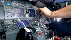 Pilot expertly operates aircraft controls in dimly lit cockpit as they adjust thrust lever for upcoming flight maneuver. Instrument panel glows with vital information and indicators. - Powered by Shutterstock - Get 15% off with code: PIKWIZARD15